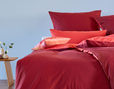 Edel-Linon Kissenbezüge Bio-Baumwolle auf Bett in den Farben Granat und Koralle