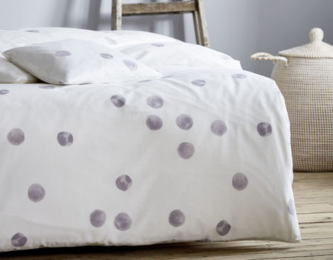 Bio Satin Bettwäsche mit grauen Tupfen auf Weiß Ausschnitt von überzogenem Bett