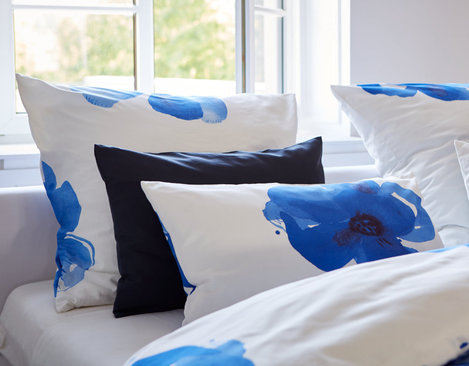 Bio Satin Bettwäsche Kollektion als Ausschnitt von Bettdecke und Kissen mit Fenster