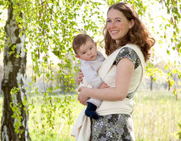 Mutter trägt Baby mit Tragetuch von Cotonea aus Bio Baumwolle in der freien Natur