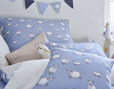 Schäfchen-Motive blau und weiß auf Bio-Kinderbettwäsche aus Baumwollsatin