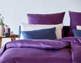 Bio Satin Bettwäsche Kollektion auf Bett im Schlafzimmer in Farbthema Beere Ausschnitt mit Nachttisch