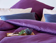 Bio Satin Bettwäsche Kollektion auf Bett im Schlafzimmer in Farbthema Beere Ausschnitt von Kissen