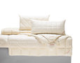 Kopfkissen aus Bio-Baumwolle mit herausnehmbarem Latexkern auf Bett drapiert mit Decken